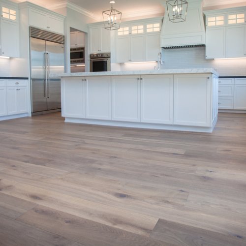 Greige wood flooring in a bright white kitchen